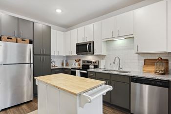 A modern kitchen with a wooden countertop and stainless steel appliances